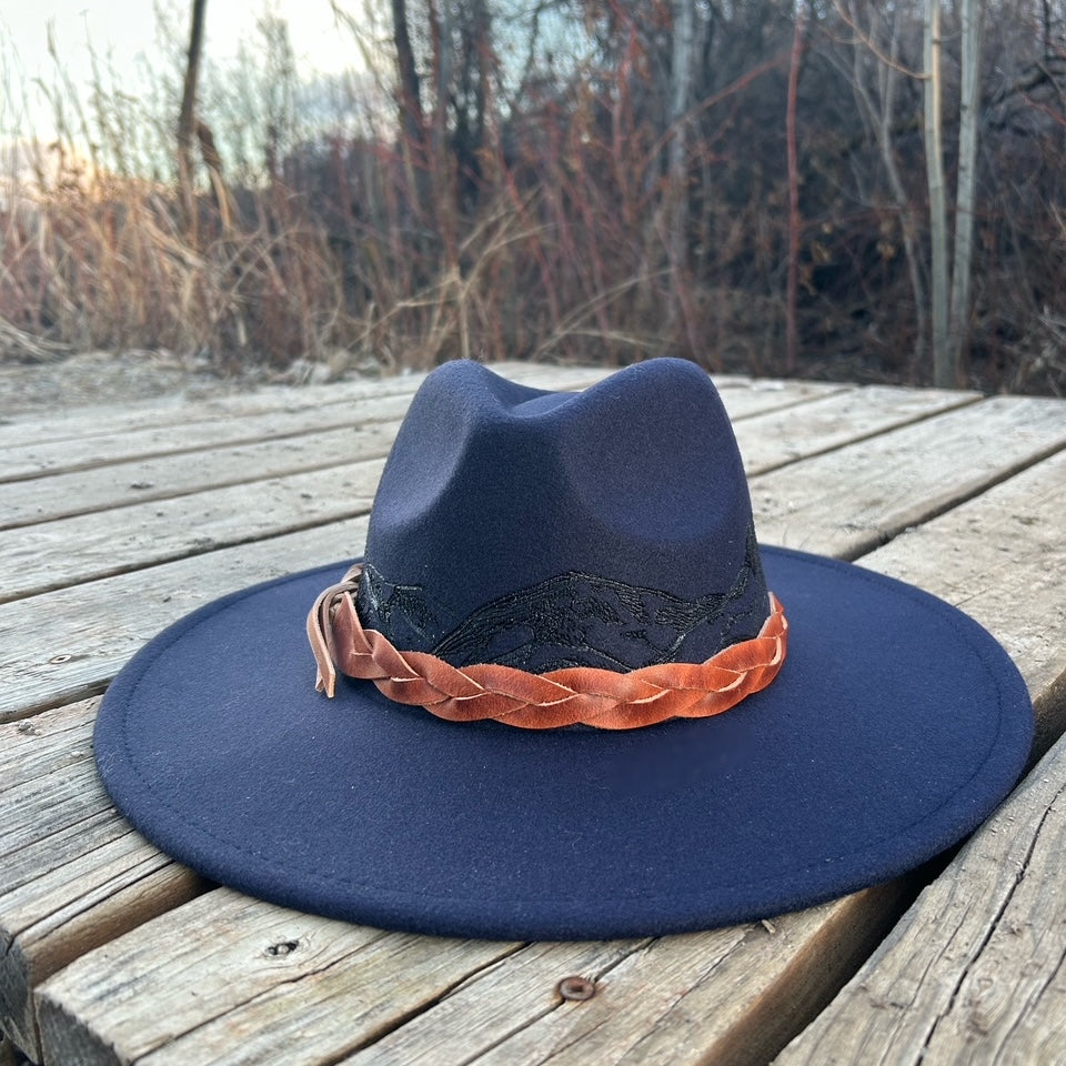 360-degree hand-burned mountain range silhouette encircling the crown of a premium felt hat. Detailed custom etching of the Rocky Mountain skyline by Hleritz Customs.