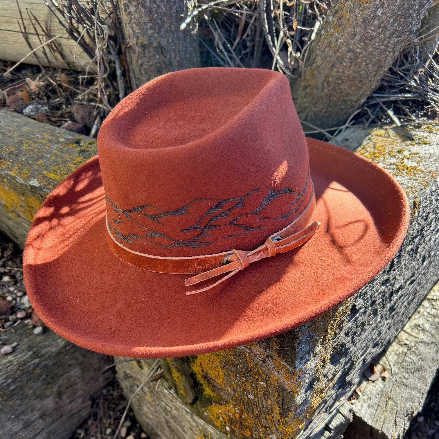 360-degree hand-burned mountain range silhouette encircling the crown of a premium felt hat. Detailed custom etching of the Rocky Mountain skyline by Hleritz Customs.