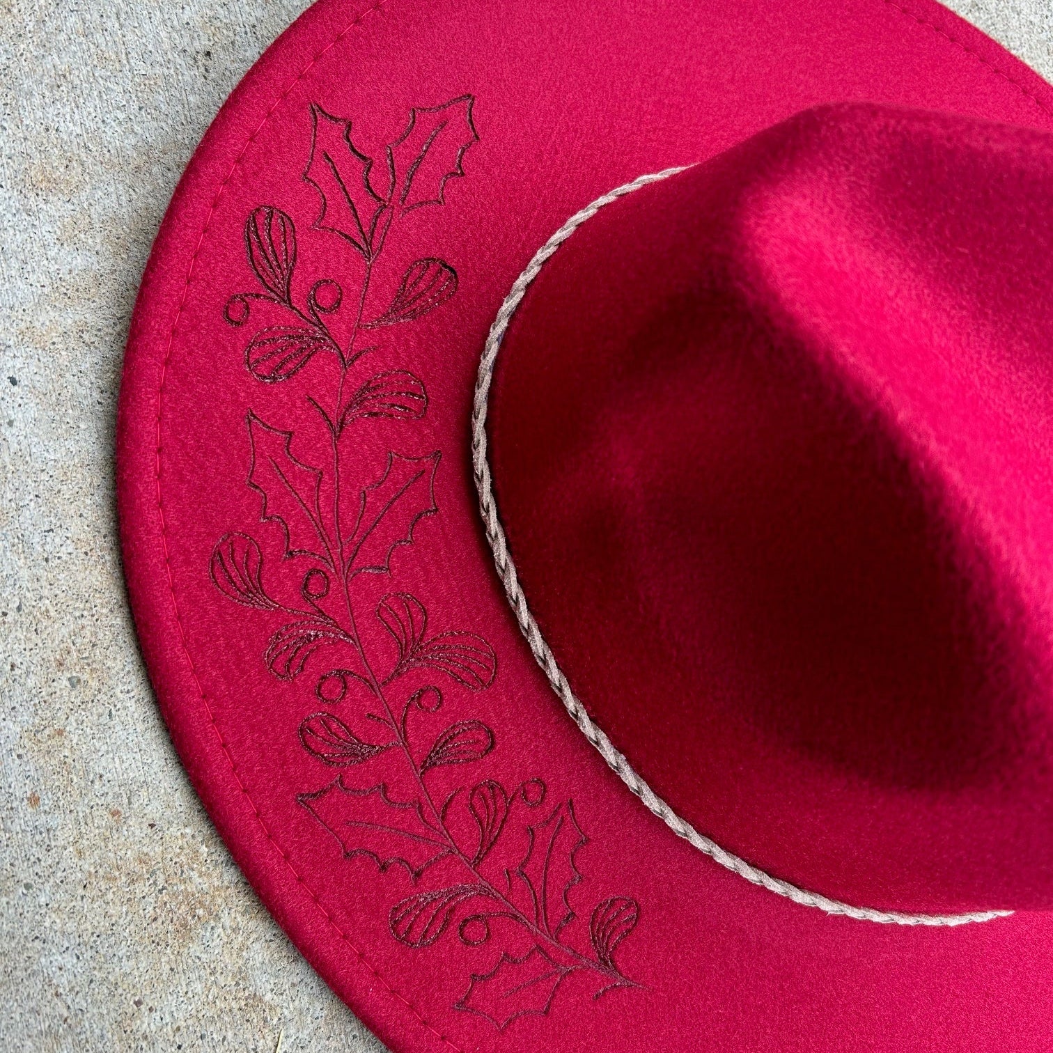Hand-etched brim of sharp, resilient holly leaves and wild berries—a tribute to the flora that thrives when everything else fades. 