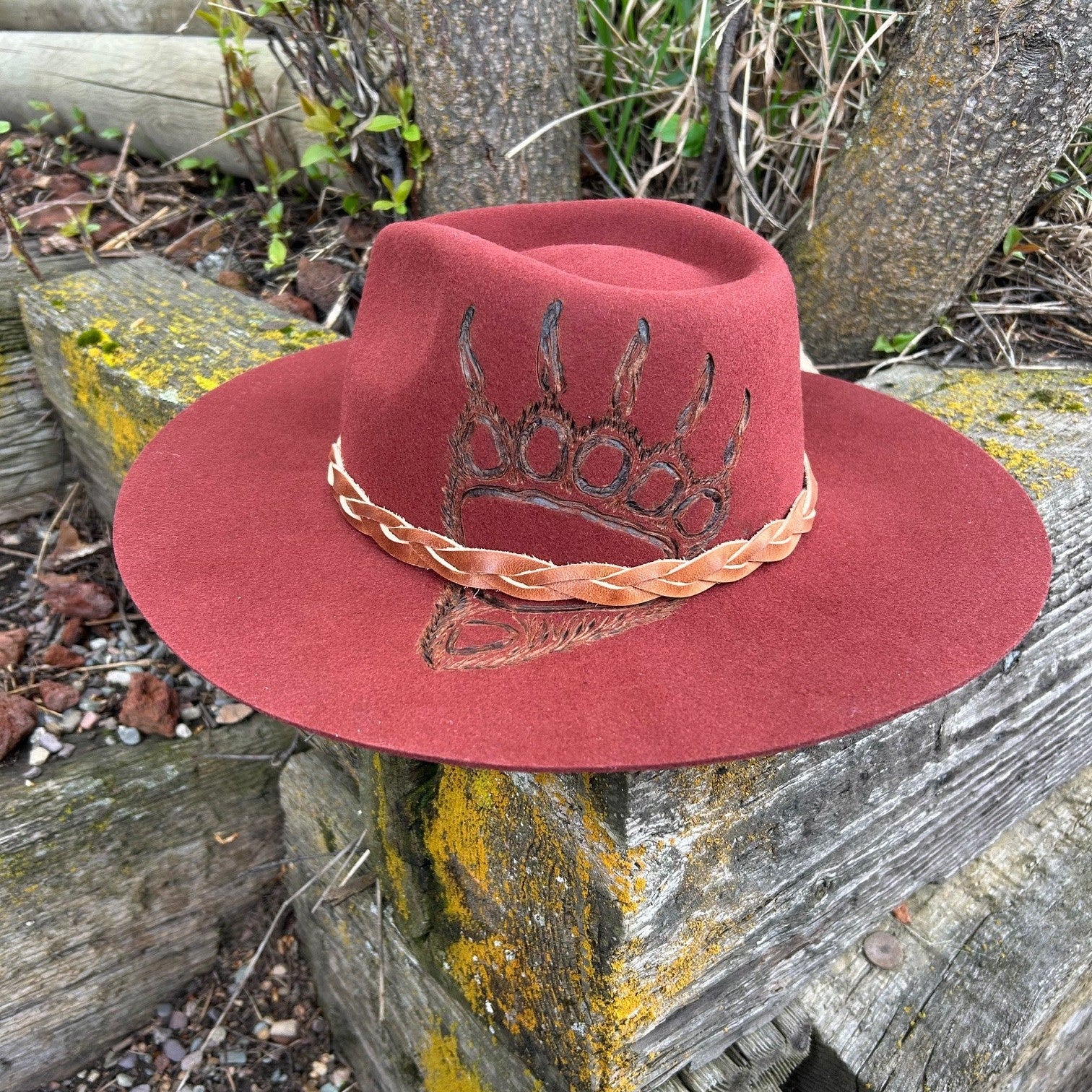 Custom grizzly bear paw pyrography on a rust wool fedora. Hand-etched wilderness art on a wide-brim felt hat with a braided leather accent, designed by Hleritz Customs.